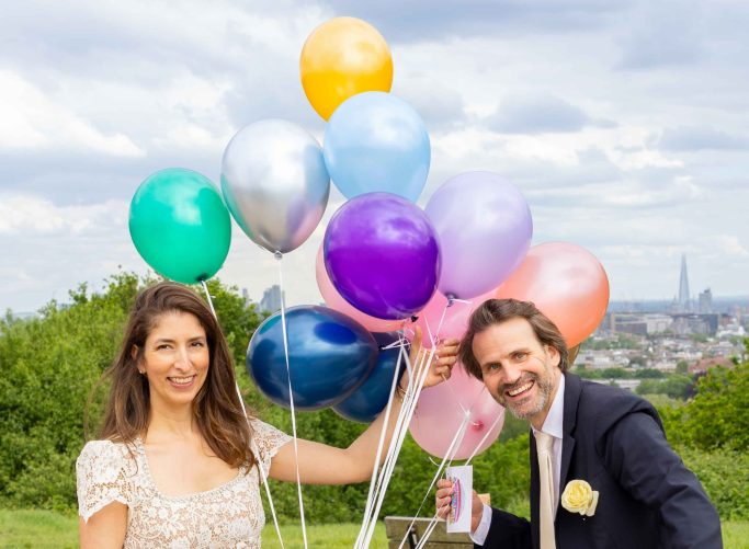 Married couple with balloons and London city view